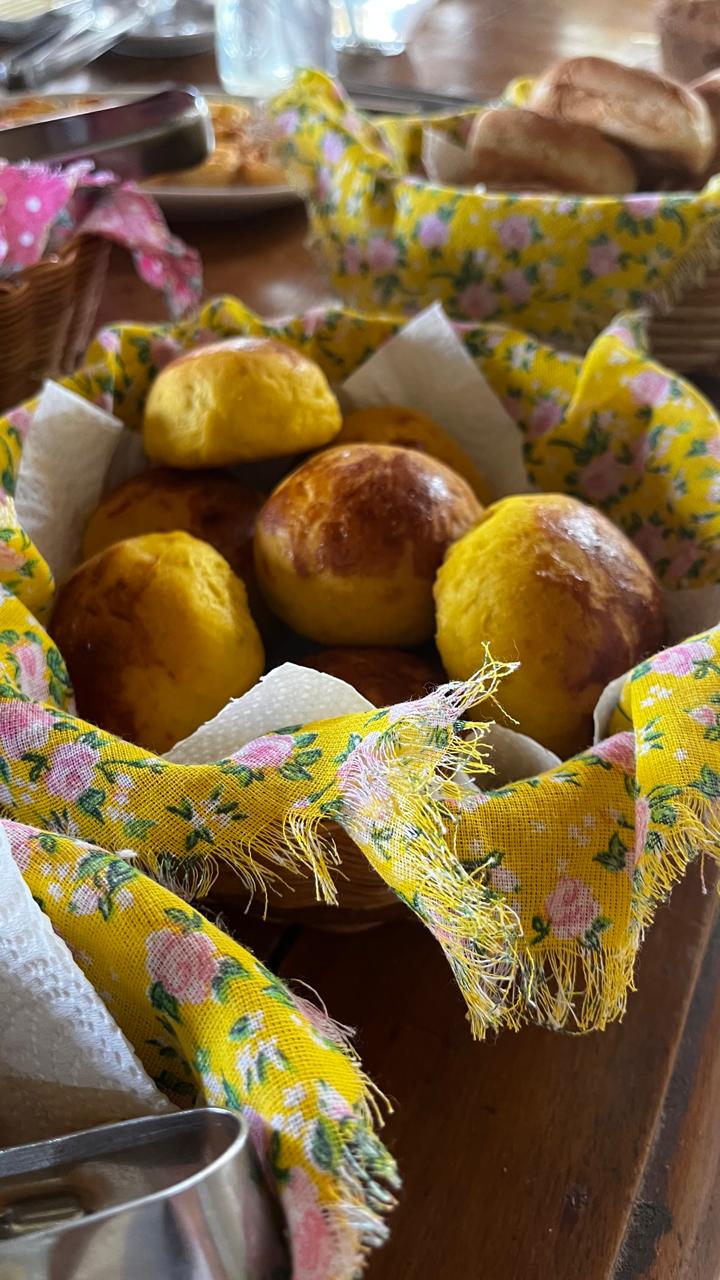 Pães de abóbora caseiros dourados servidos em cesta com tecido estampado